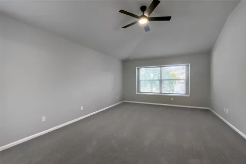 an empty room with a window and a fan