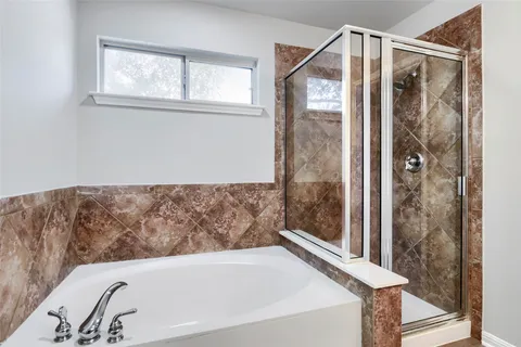 a bathroom with a bathtub and shower