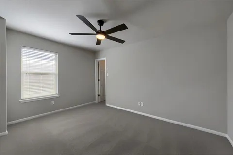 an empty room with a window and a fan