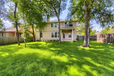 a view of a house with a backyard and a tree