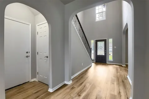 a view of a hallway with wooden floor and staircase