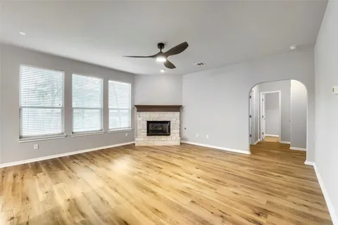 a view of an empty room with a fireplace and a window