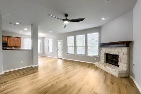 a view of an empty room with a fireplace and a window