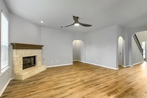 a view of empty room with wooden floor and fireplace