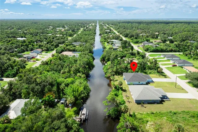 an aerial view of residential house with outdoor space and trees all around
