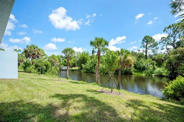 a view of a lake with a yard and large trees