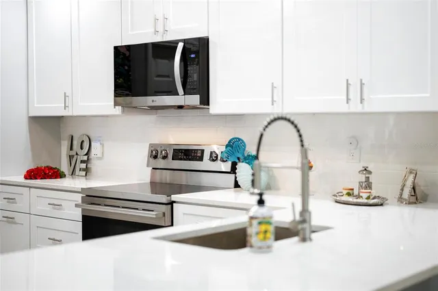 a kitchen with white cabinets and white appliances