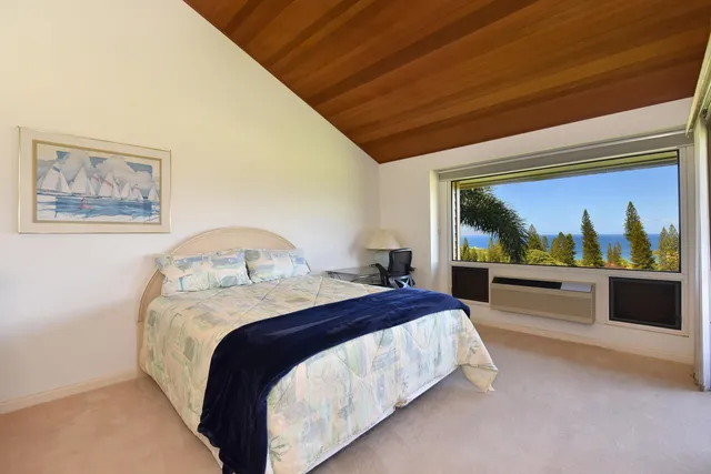 a spacious bedroom with a bed and a large window