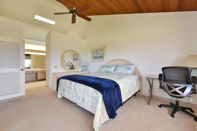 a spacious bedroom with a bed and a chair