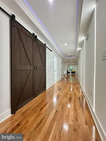 a large kitchen with stainless steel appliances kitchen island a large counter top and a wooden floors