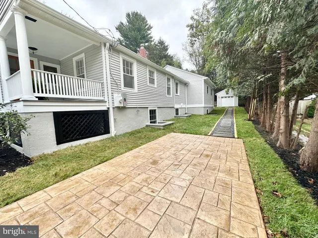 a front view of a house with a yard and trees