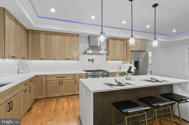 a kitchen with a sink stove cabinets and wooden floor
