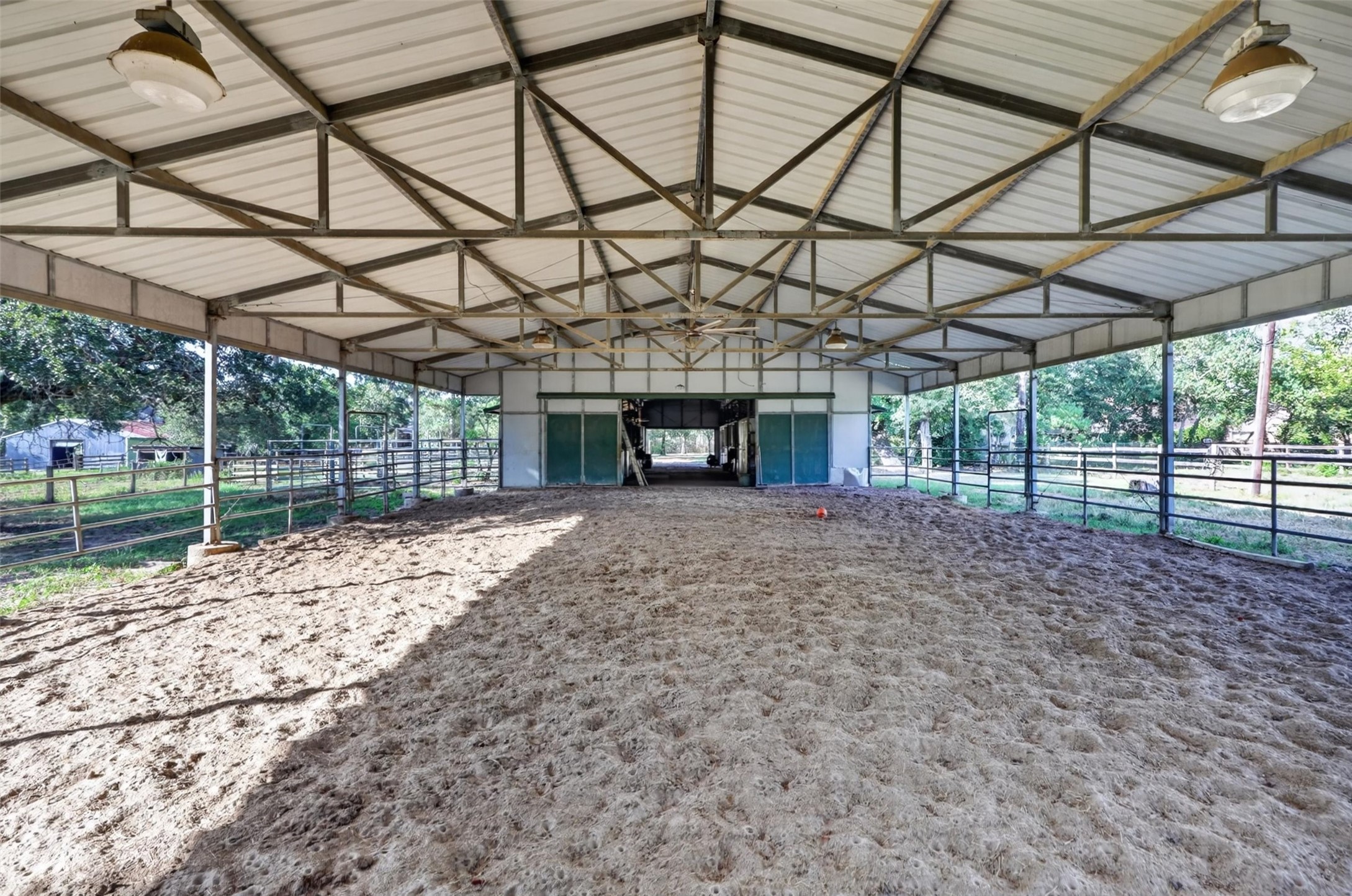 12625 Huffmeister Road Cypress, TX 77429 - Photo 33 of 50 Where passion for horses meets the freedom of country living! One of two riding arenas at Cy-Creek Ranch, this spacious covered arena features a sand riding surface, sturdy metal fencing, and direct access to the horse barn. Whether enjoying an early morning ride, training your horses, or passing down a love of equestrian life to the next generation, this arena offers a special place to create lasting memories, rain or shine!