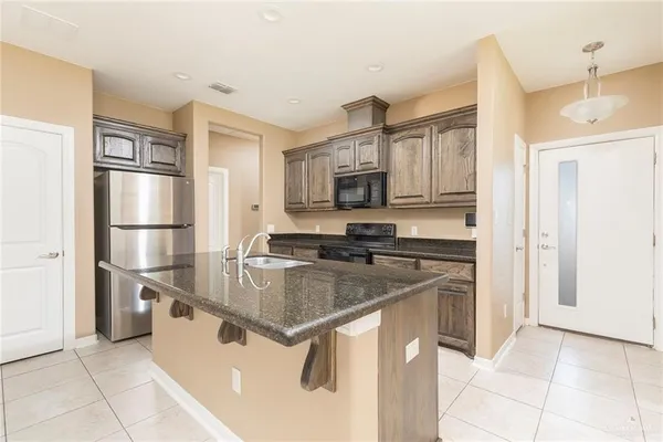 a kitchen with stainless steel appliances granite countertop a refrigerator a stove and a sink