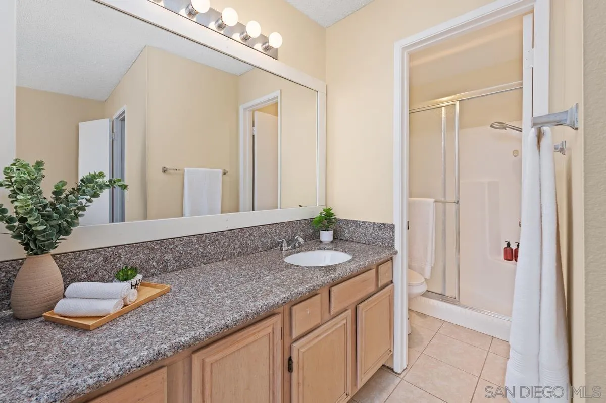 2332 Hosp Way, Unit 207 Carlsbad, CA 92008 - Photo 15 of 31 a bathroom with a granite countertop sink and a mirror