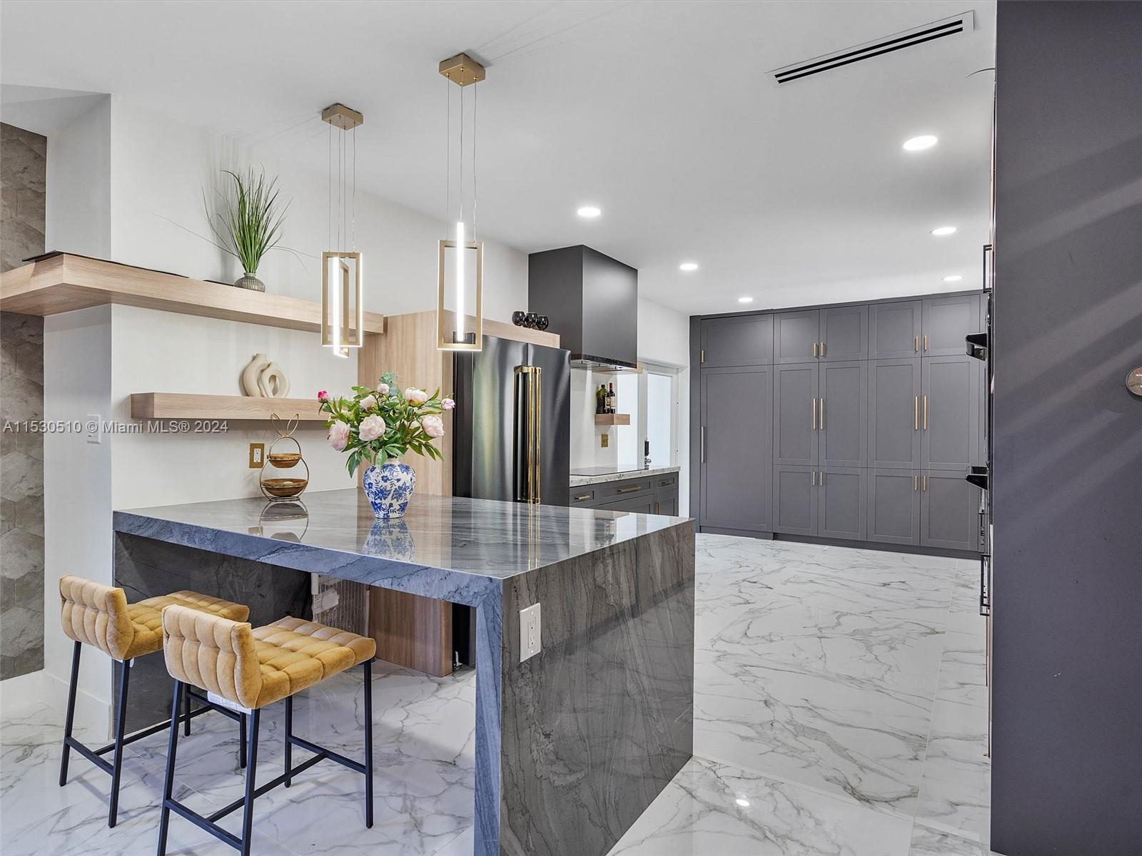 4431 Alton Road, Unit 1 Miami Beach, FL 33140 - Photo 19 of 60 a kitchen with stainless steel appliances kitchen island granite countertop a refrigerator and cabinets