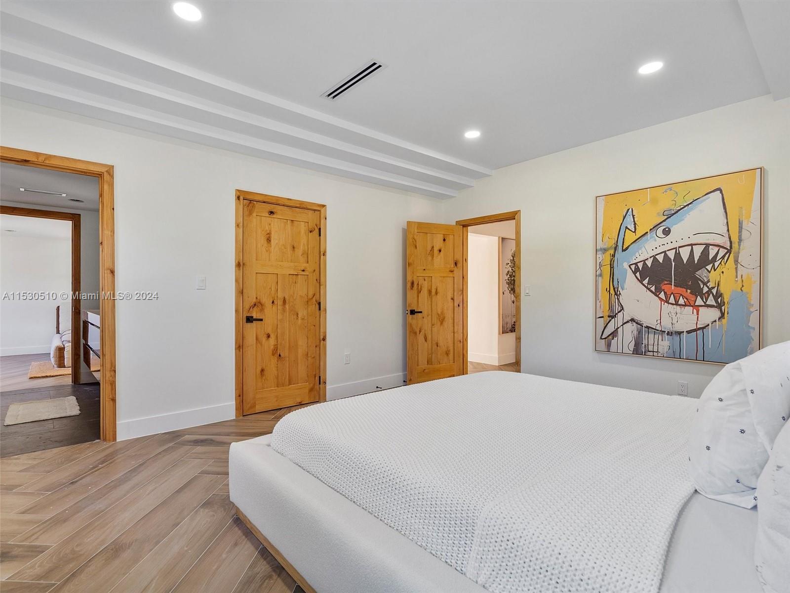 4431 Alton Road, Unit 1 Miami Beach, FL 33140 - Photo 27 of 60 a spacious bedroom with a bed and a table