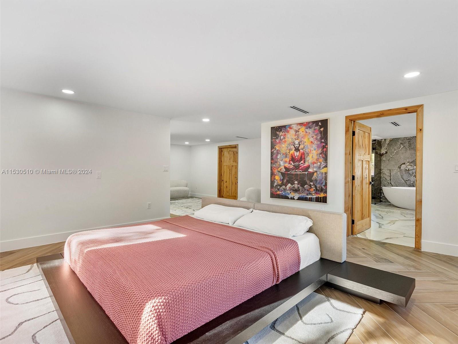 4431 Alton Road, Unit 1 Miami Beach, FL 33140 - Photo 32 of 60 a bedroom with a large bed and a painting on the wall