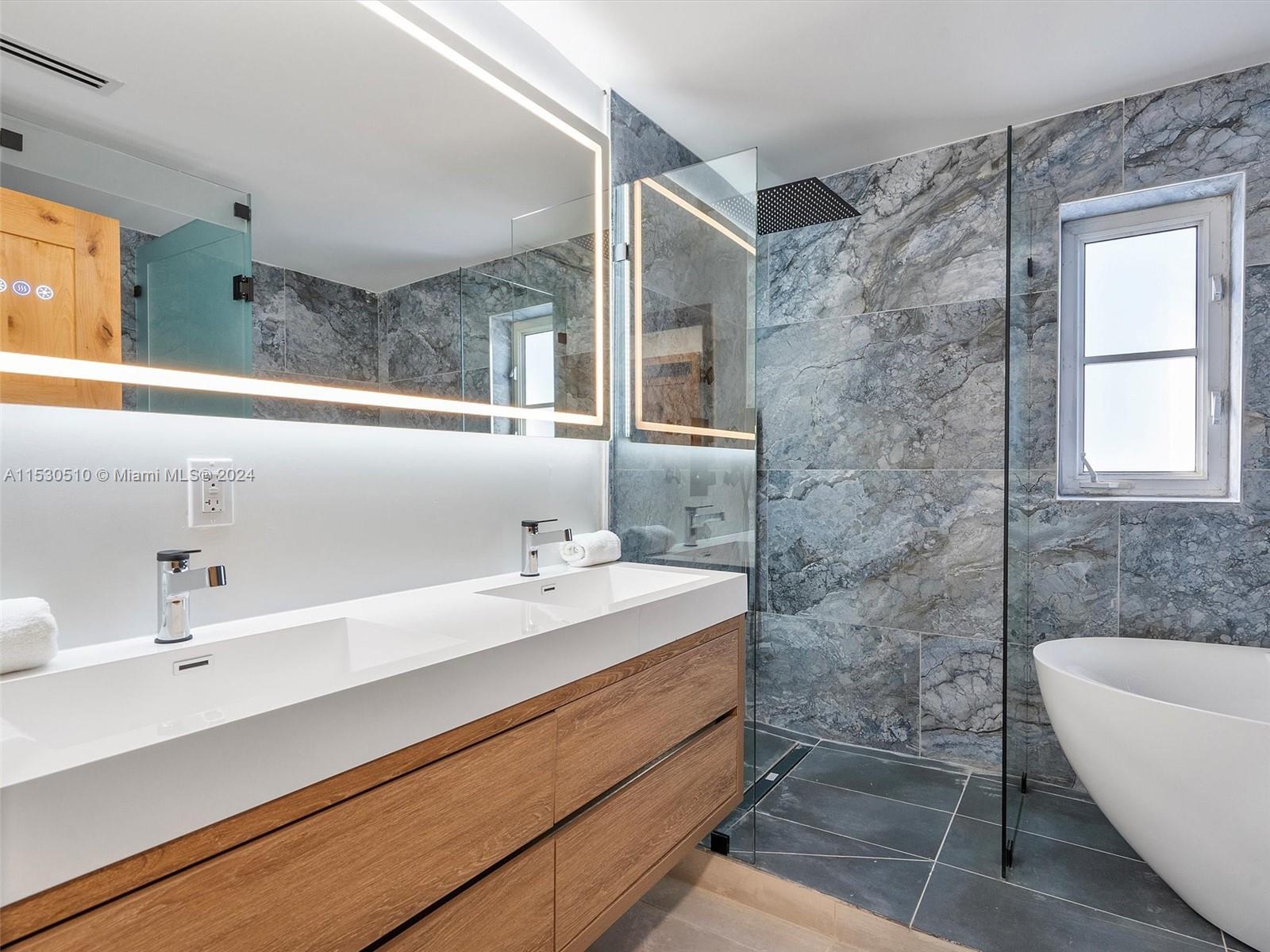 4431 Alton Road, Unit 1 Miami Beach, FL 33140 - Photo 43 of 60 a bathroom with a sink and a mirror