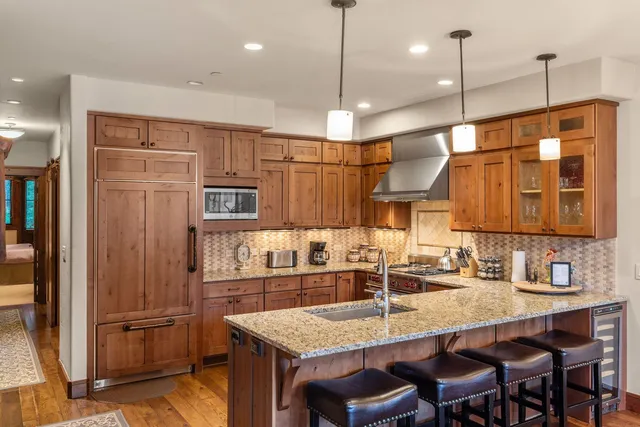 a kitchen with stainless steel appliances granite countertop a sink refrigerator and cabinets