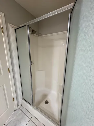 a bathroom with a glass door shower and a sink