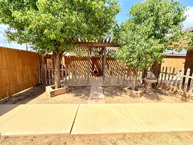 a view of a patio with a table and chairs and wooden fence