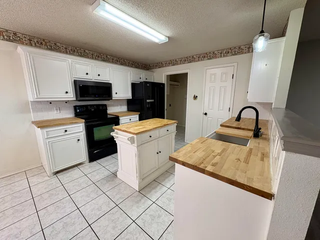 a kitchen with a sink appliances and cabinets