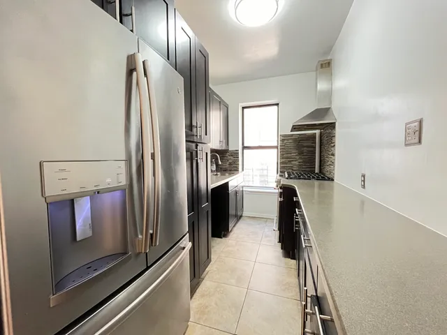 a kitchen with stainless steel appliances a refrigerator and a stove top oven
