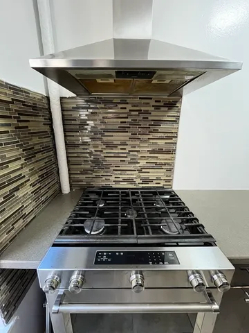 a stove top oven sitting inside of a kitchen