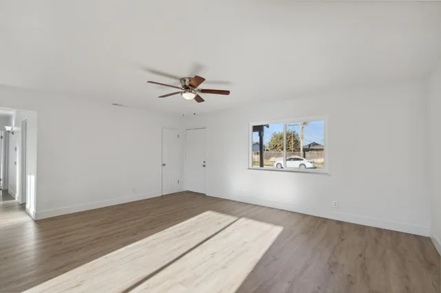 a view of a room with wooden floor and fan