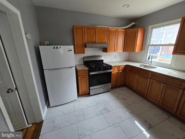 a kitchen with a refrigerator a stove a sink and a window
