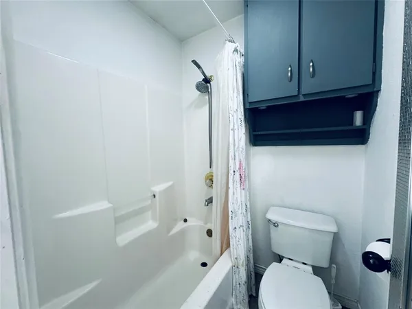 a bathroom with a toilet and a shower