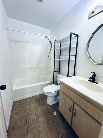 a bathroom with a granite countertop sink toilet a mirror and shower