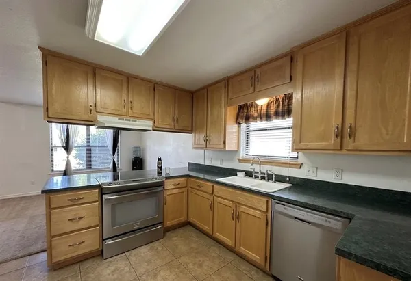 a kitchen with cabinets appliances a sink and a window