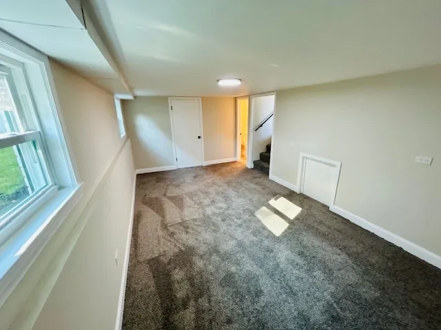 a view of empty room with wooden floor and window