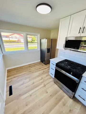 a kitchen with stainless steel appliances kitchen island a stove and a window