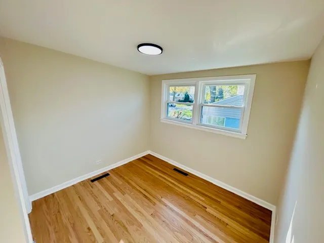 a view of a room with wooden floor and a window