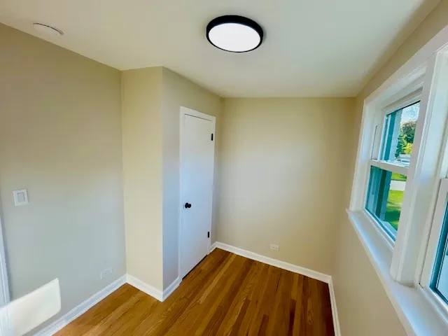 a view of a room with wooden floor and windows