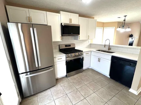 a kitchen with a refrigerator sink and microwave