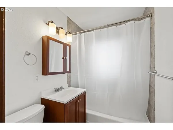 a bathroom with a sink mirror and a shower