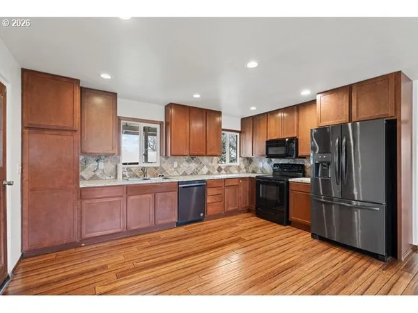 a kitchen with granite countertop stainless steel appliances refrigerator cabinets microwave and stove