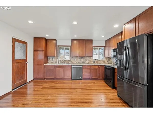 a kitchen with stainless steel appliances granite countertop a refrigerator and a sink