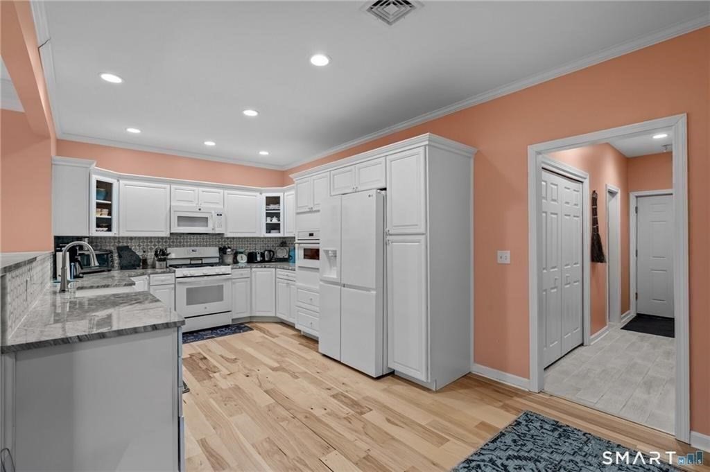 117 New Road Thompson, CT 06277 - Photo 15 of 29 a kitchen with white cabinets and stainless steel appliances