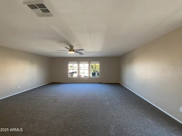 an empty room with windows and fireplace