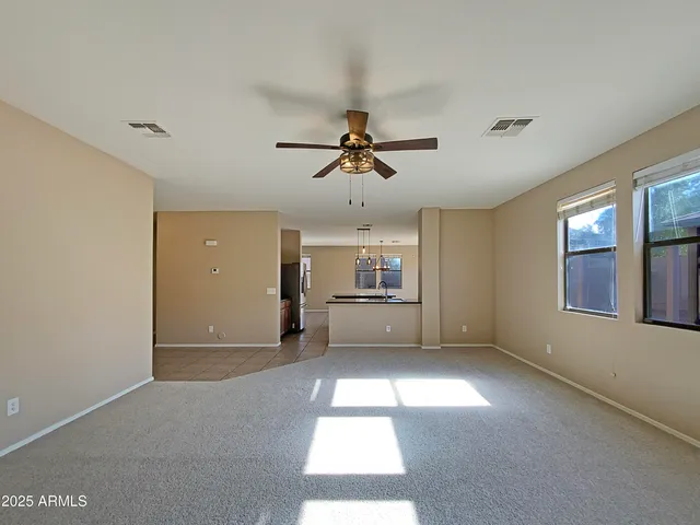 a view of a room with a ceiling fan and window
