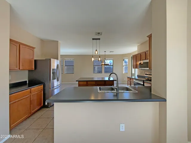 a kitchen with kitchen island a counter top space cabinets and stainless steel appliances