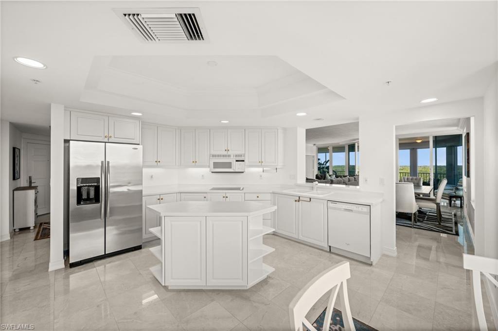 445 Dockside Drive, Unit A504 Naples, FL 34110 - Photo 13 of 50 a kitchen with white cabinets and stainless steel appliances