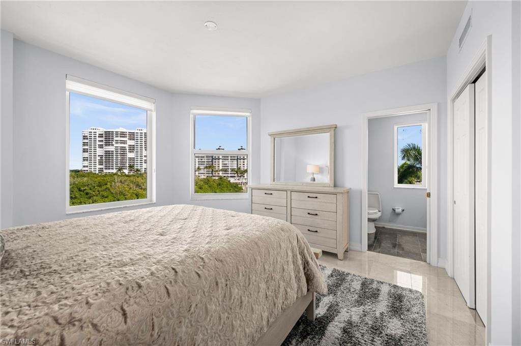 445 Dockside Drive, Unit A504 Naples, FL 34110 - Photo 21 of 50 a spacious bedroom with a bed and a dresser
