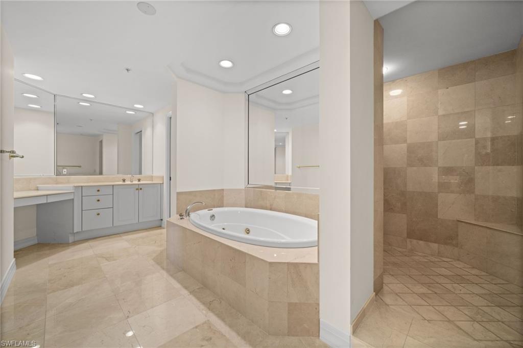 445 Dockside Drive, Unit A504 Naples, FL 34110 - Photo 35 of 50 a large bathroom with a sink a toilet a shower a mirror and bathtub