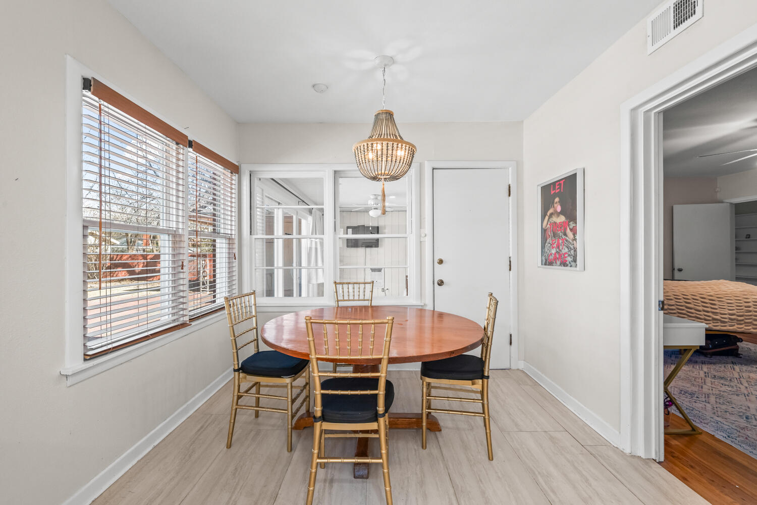 3310 24th Street Lubbock, TX 79410 - Photo 21 of 65 a dining room with wooden floor a chandelier a wooden table and chairs
